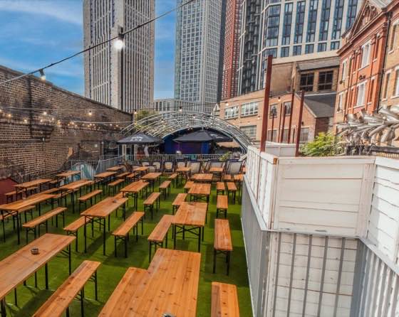 The rooftop terrace — open-air benches with the city skyline behind